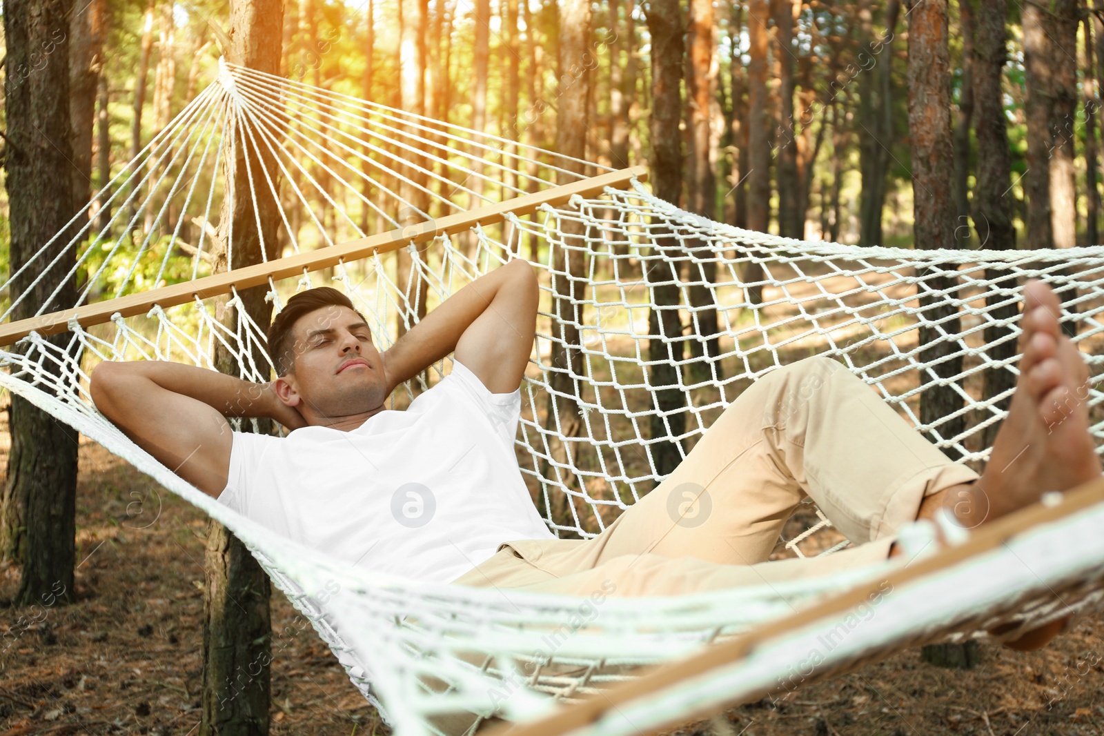 Photo of Handsome man resting in hammock outdoors on summer day