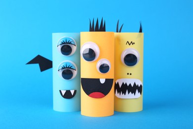 Photo of Spooky paper monsters on light blue background. Halloween decoration