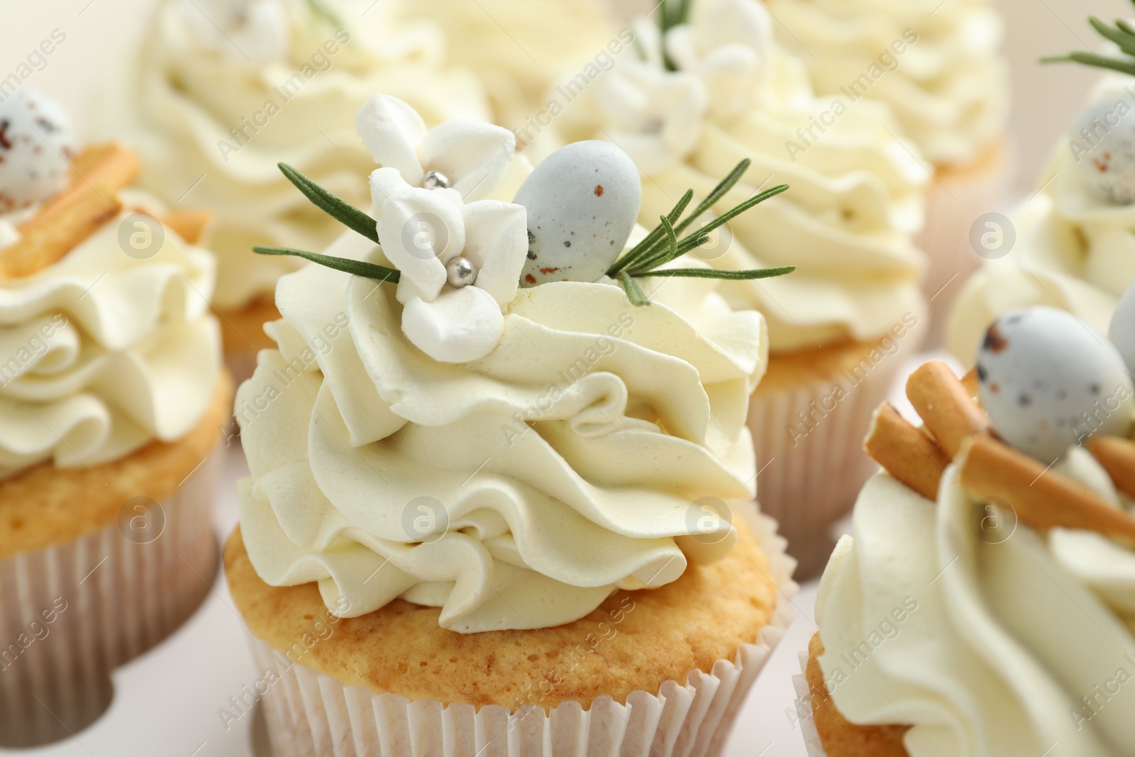 Photo of Tasty Easter cupcakes with vanilla cream in box, closeup