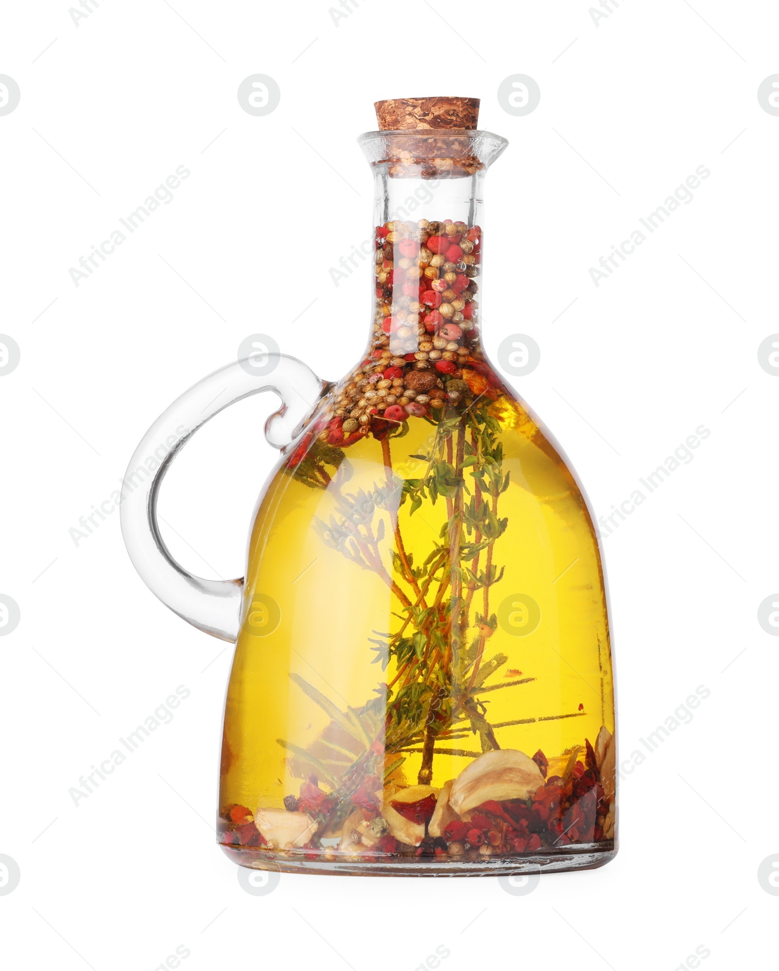 Photo of Glass jug of cooking oil with spices and herbs isolated on white