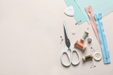 Photo of Set of tailoring accessories on light background, top view