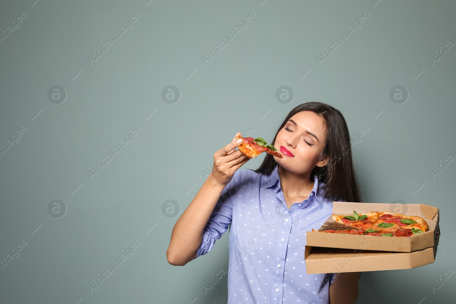 Photo of Attractive young woman with delicious pizza on color background