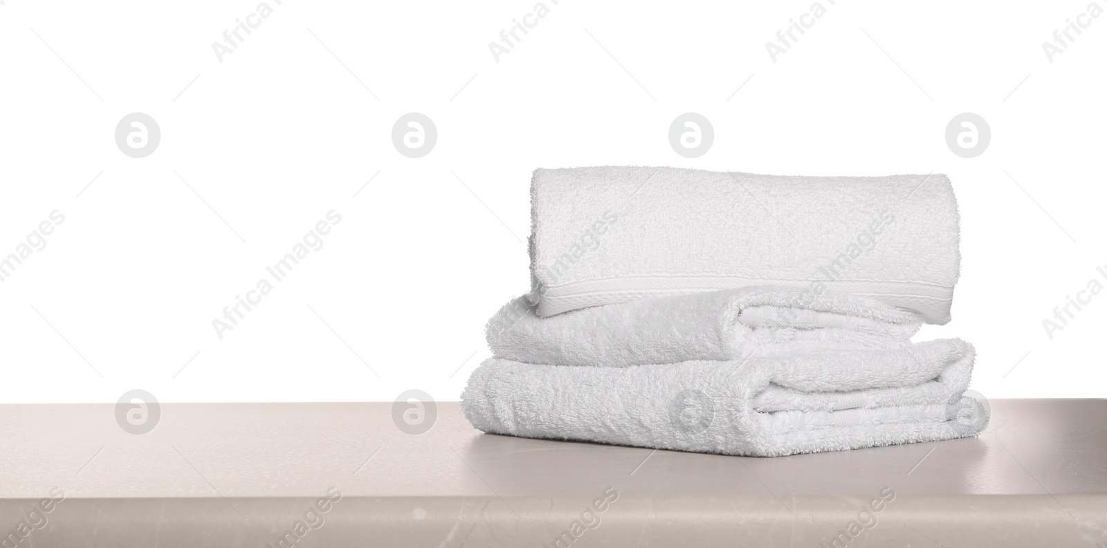 Photo of Soft terry towels on light table against white background, space for text