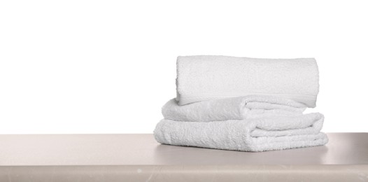Photo of Soft terry towels on light table against white background, space for text