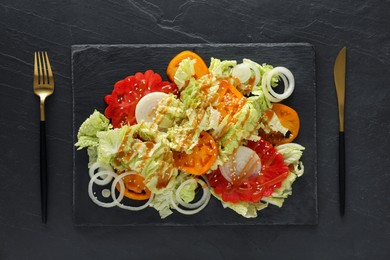 Photo of Delicious salad with Chinese cabbage, tomatoes and onion served on black table, flat lay