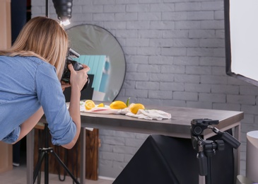 Woman taking photo of food with professional camera in studio