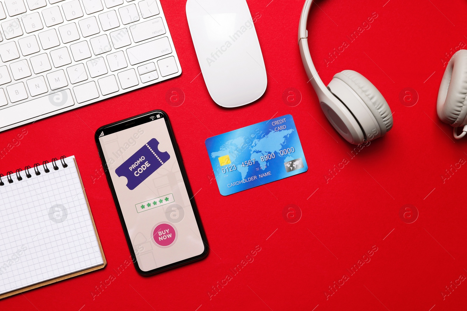 Photo of Flat lay composition of smartphone with activated promo code on red table
