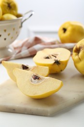 Photo of Tasty ripe quinces on white wooden table, closeup