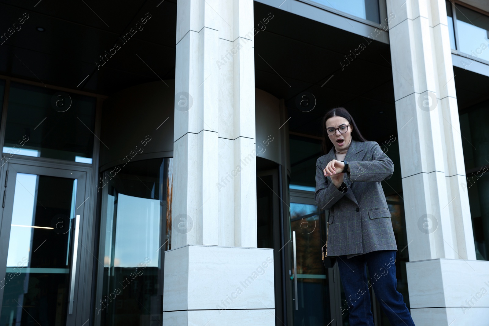 Photo of Emotional woman checking time on watch outdoors. Being late concept