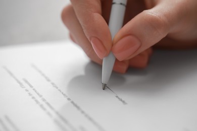 Photo of Woman signing documents on white background, closeup