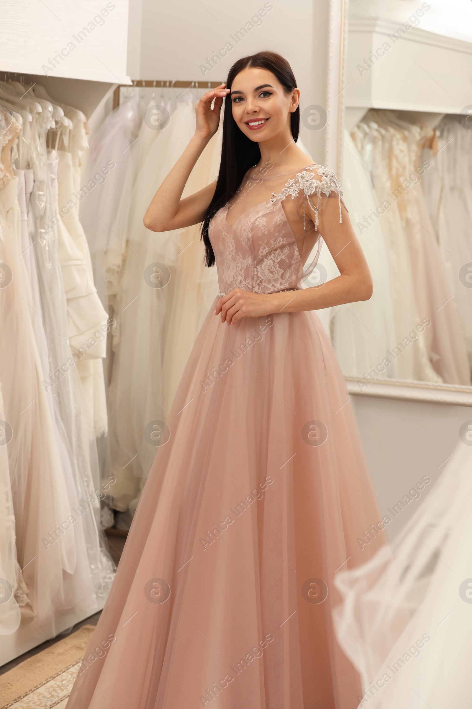 Photo of Woman trying on wedding dress in boutique