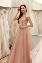 Photo of Woman trying on wedding dress in boutique