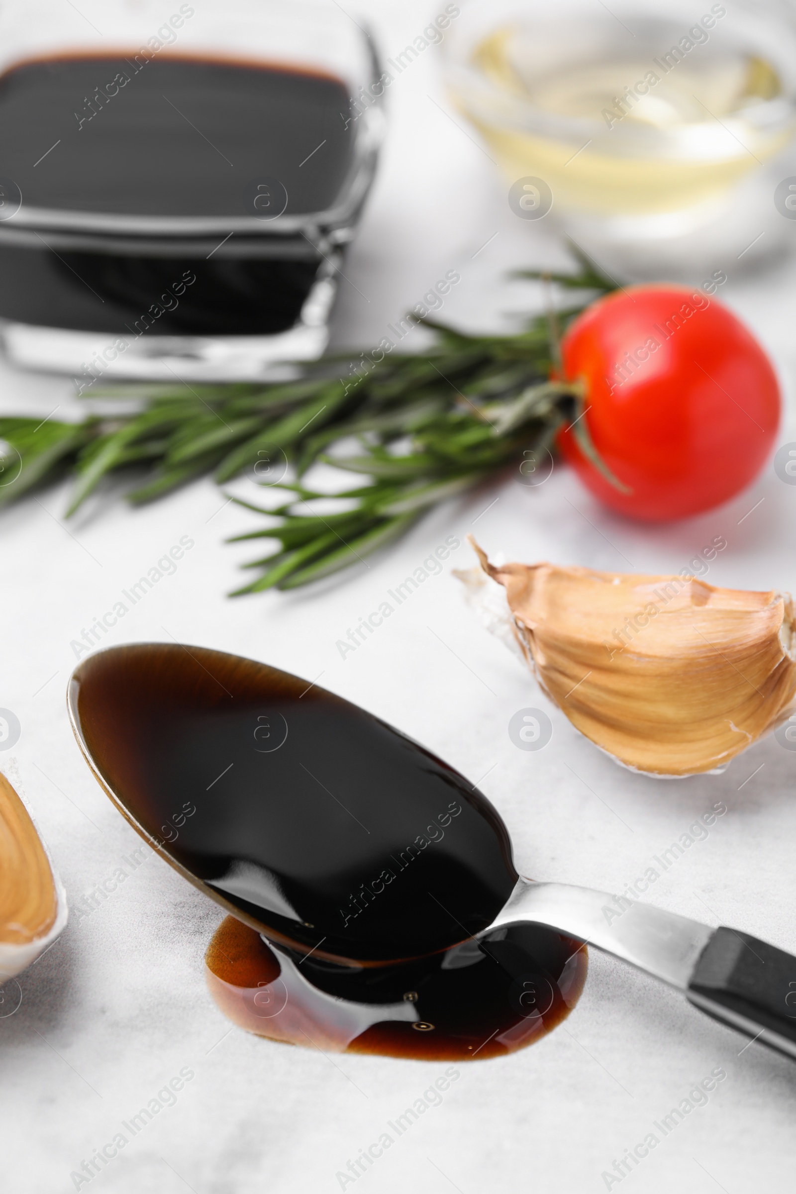 Photo of Organic balsamic vinegar and cooking ingredients on white table, closeup