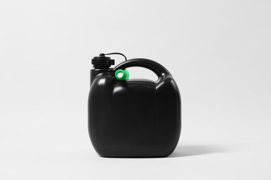 Photo of Black plastic canister with nozzle on light grey background