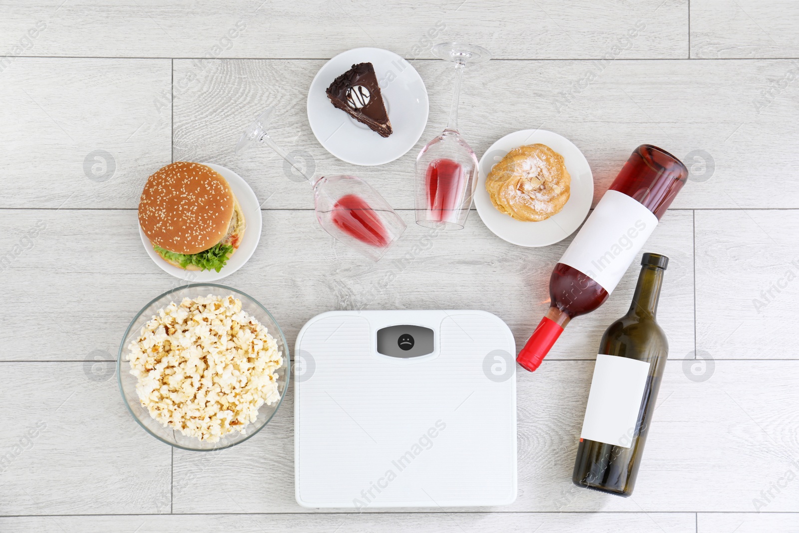 Photo of Flat lay composition with scales, different food and alcohol on floor. After party chaos