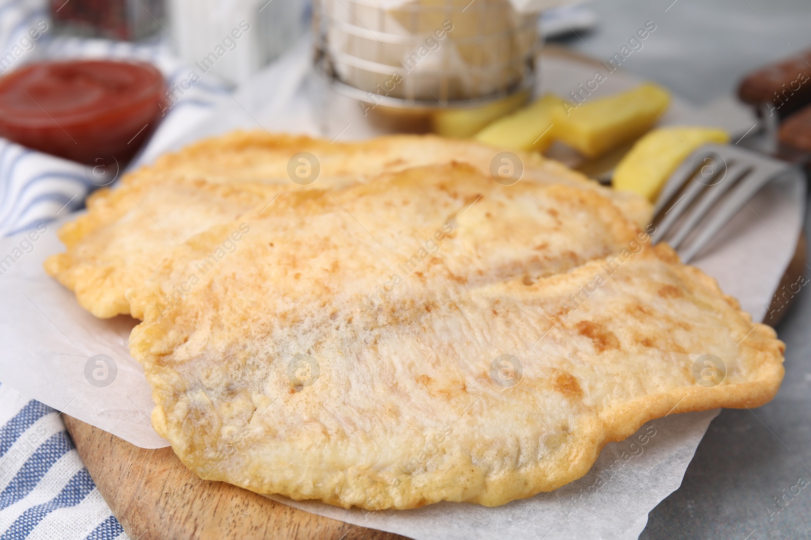 Photo of Delicious fish and chips served on table, closeup