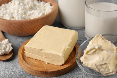 Photo of Piece of tasty homemade butter and dairy products on grey table