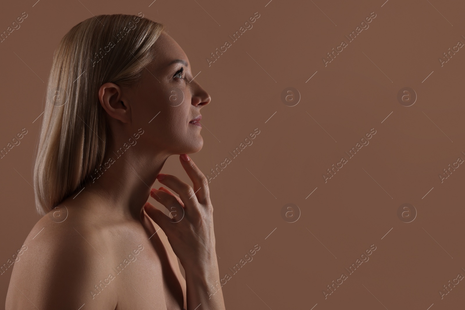 Photo of Beautiful woman touching her neck on beige background, space for text