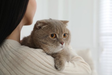 Photo of Woman with her adorable cat at home, closeup