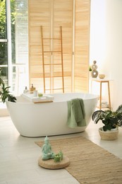 Stylish bathroom interior with modern tub and beautiful houseplants