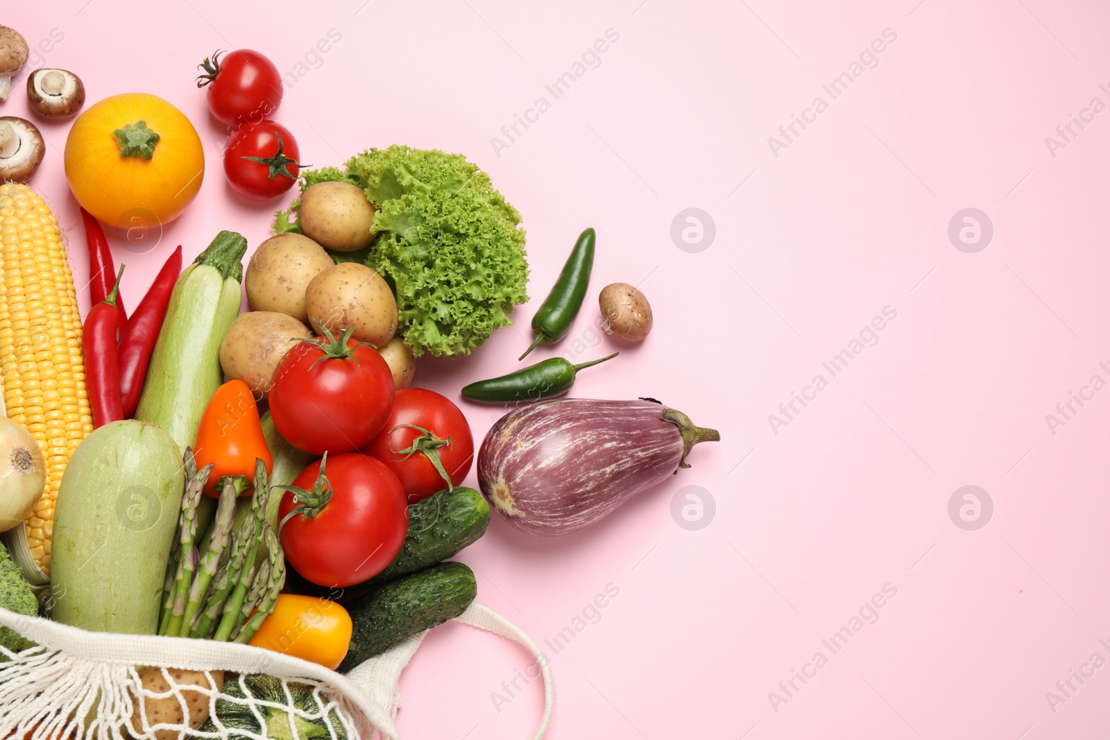 Photo of Different fresh vegetables on pink background, flat lay. Space for text