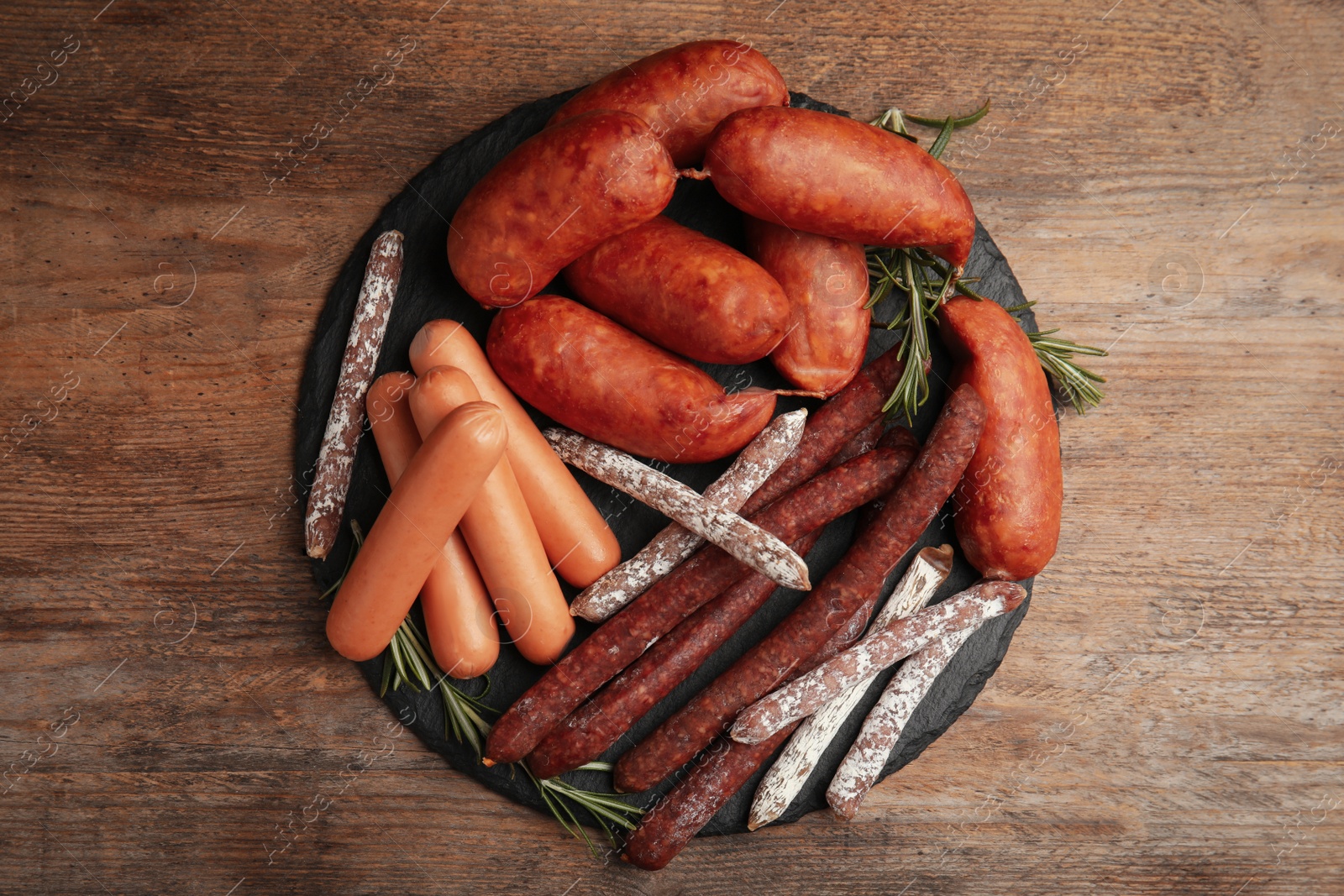 Photo of Different tasty sausages on wooden table, top view