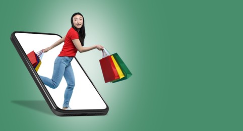 Image of Online shopping. Happy woman with paper bags walking out from smartphone on green background, space for text. Banner design