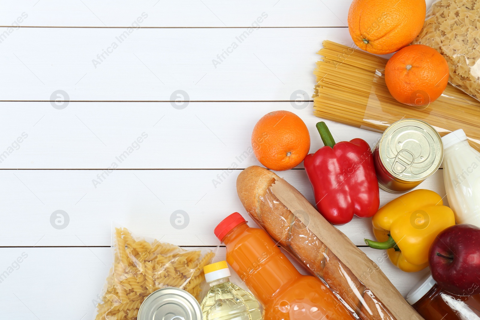 Photo of Humanitarian aid. Different food products for donation on white wooden table, flat lay. Space for text