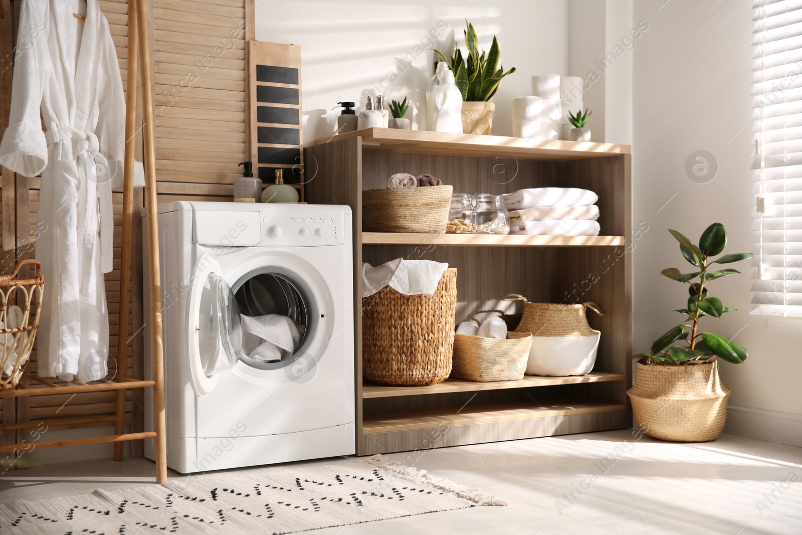 Photo of Modern washing machine and shelving unit in laundry room interior