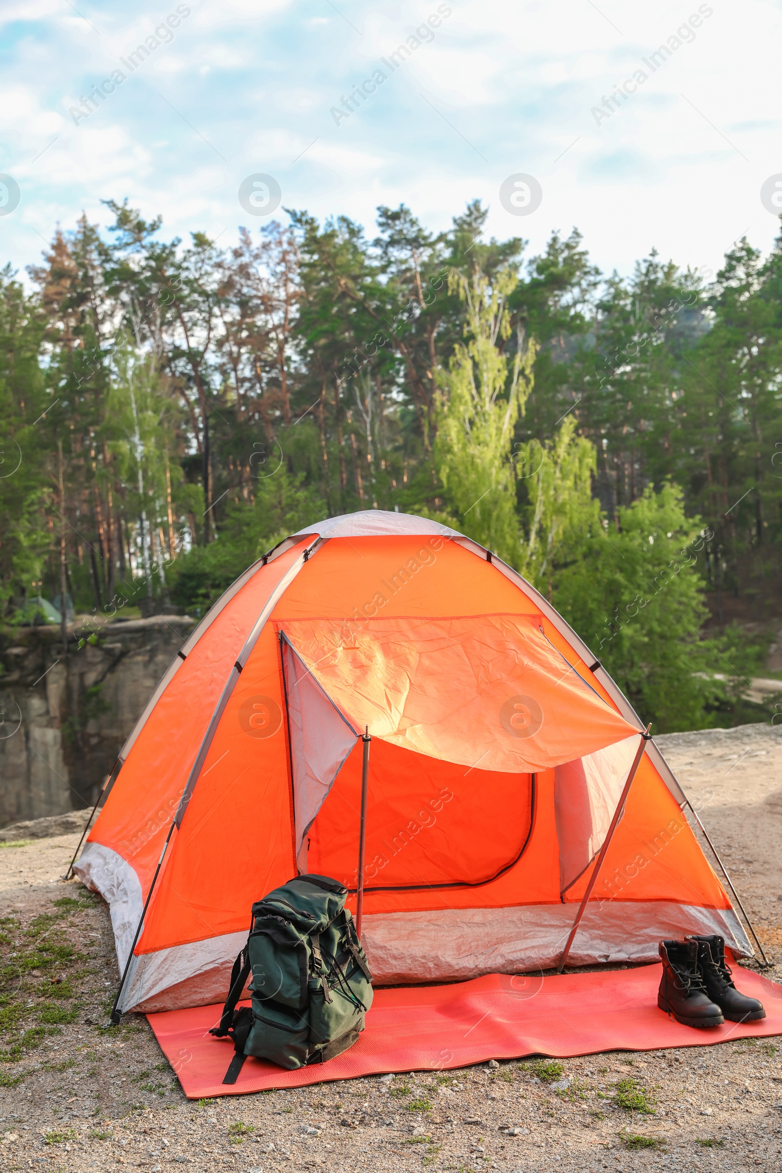 Photo of Camping tent and accessories in wilderness on summer day