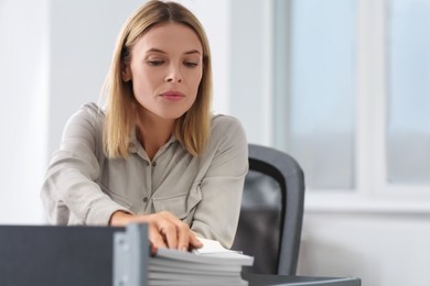 Photo of Businesswoman working with documents at table in office