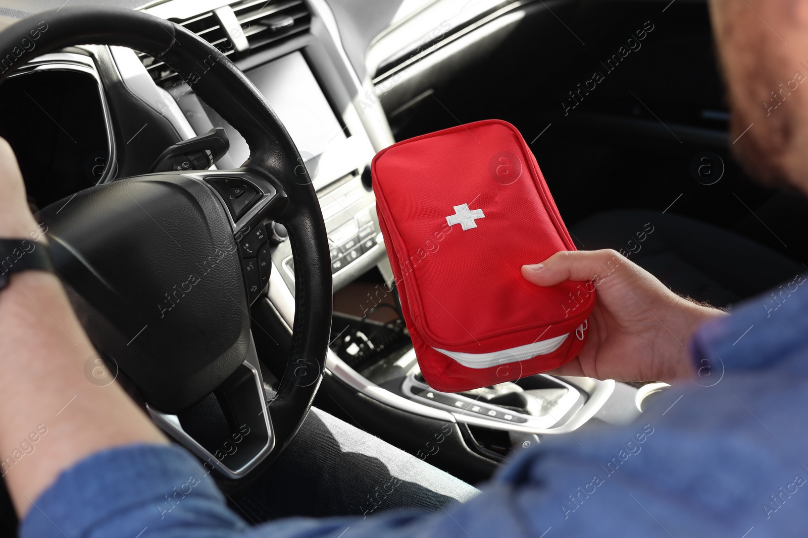 Photo of Man with first aid kit inside car, closeup