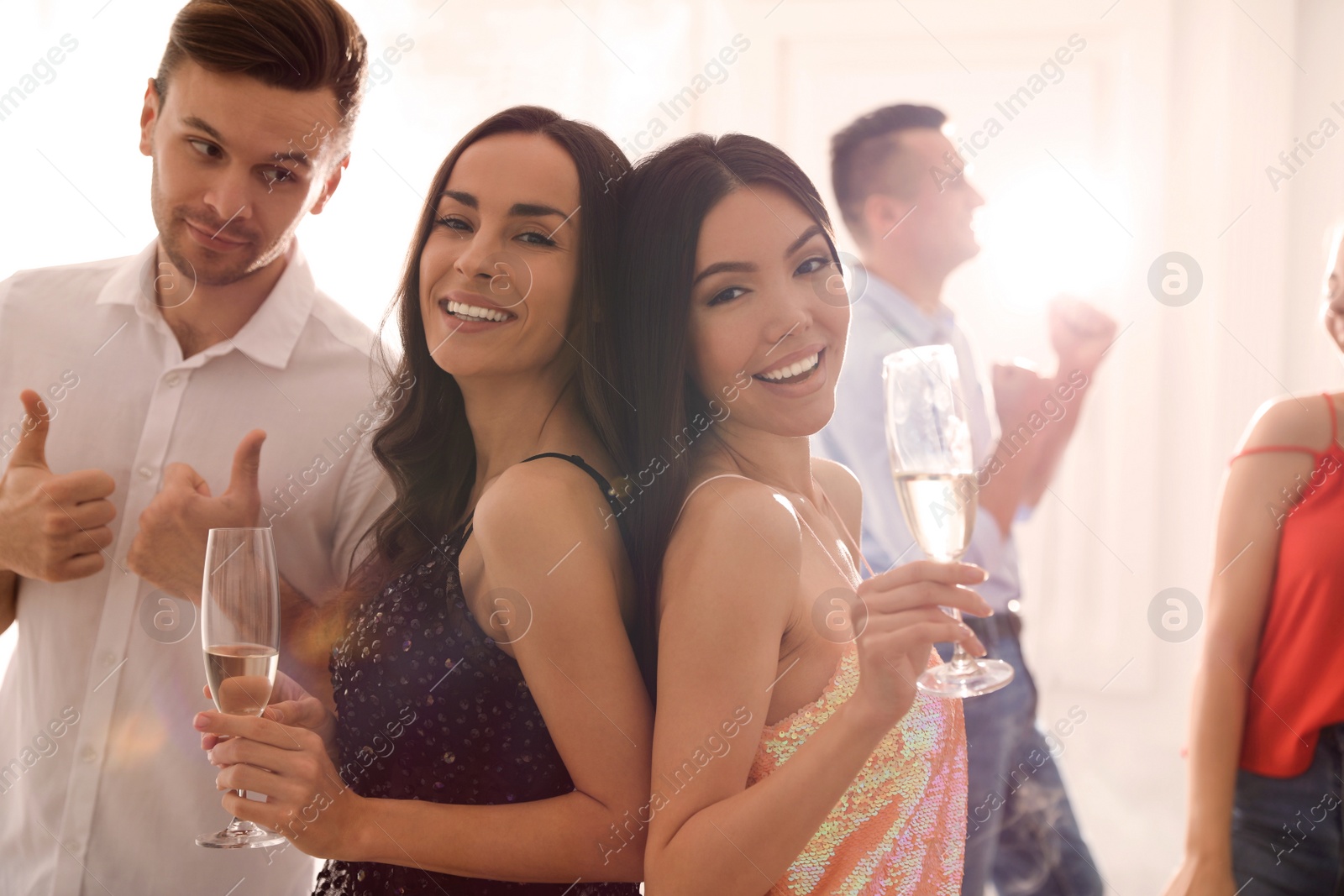 Photo of Couple of happy friends with champagne dancing at party