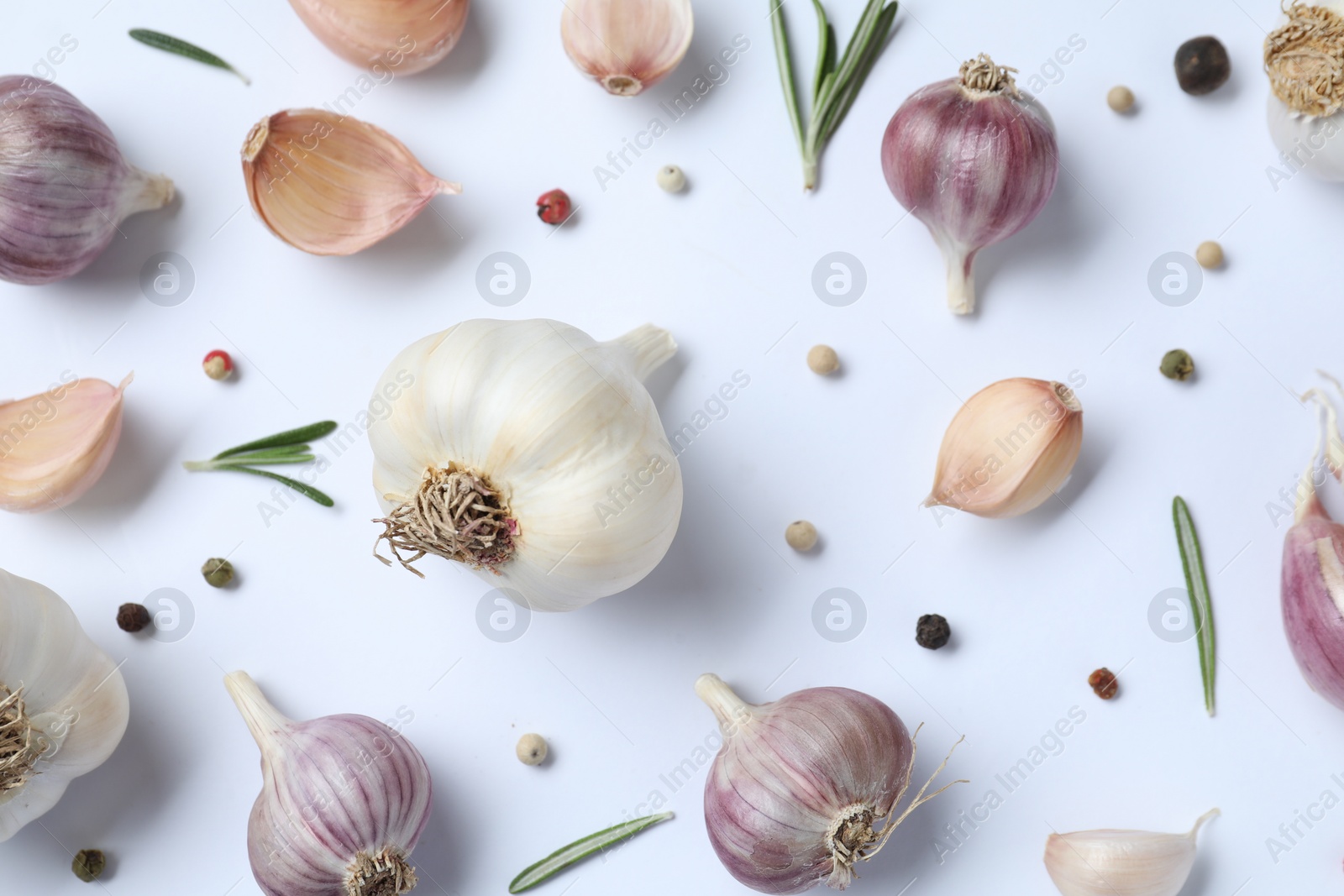 Photo of Fresh garlic, rosemary and peppercorns on white background, flat lay