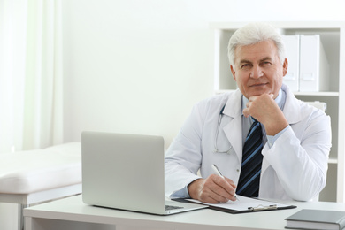 Photo of Portrait of senior doctor in white coat at workplace