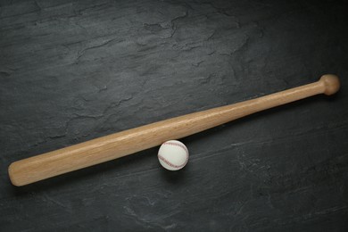 Photo of Baseball bat and ball on black background, top view. Sports equipment