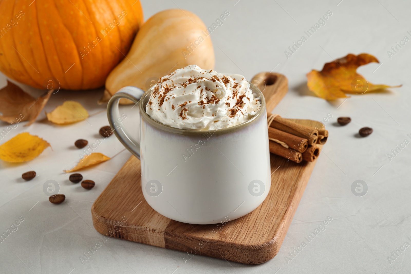 Photo of Cup with tasty pumpkin spice latte on light table