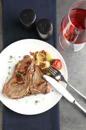 Delicious fried beef meat and vegetables served on grey table, top view