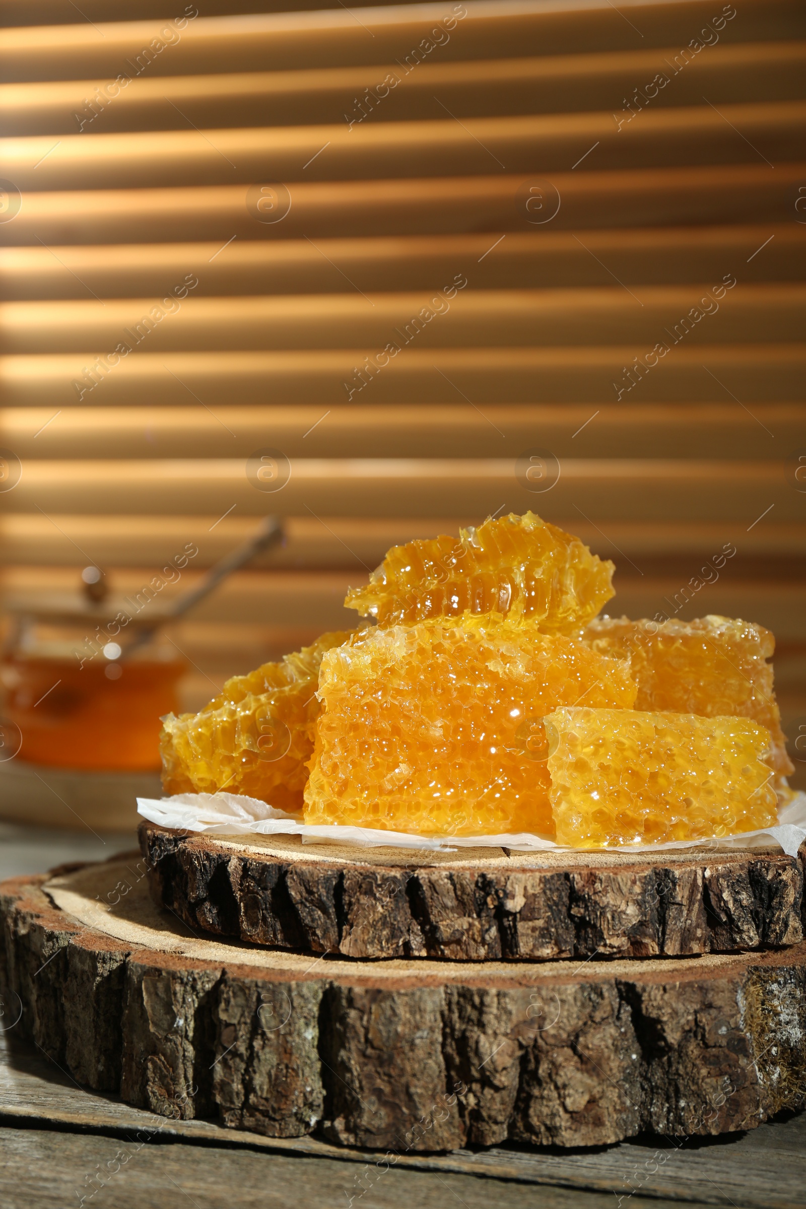 Photo of Natural honeycombs with honey on rustic table, space for text