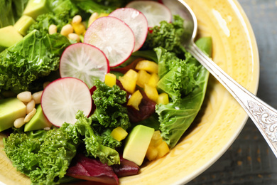 Photo of Delicious fresh kale salad in bowl, closeup