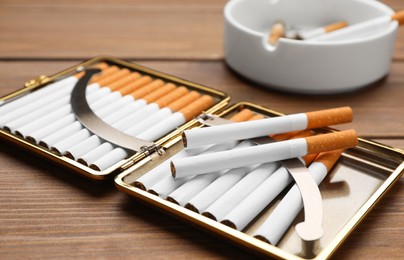 Photo of Stylish case with cigarettes on wooden table, closeup