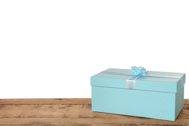 Photo of Light blue gift box with bow on wooden table against white background, space for text