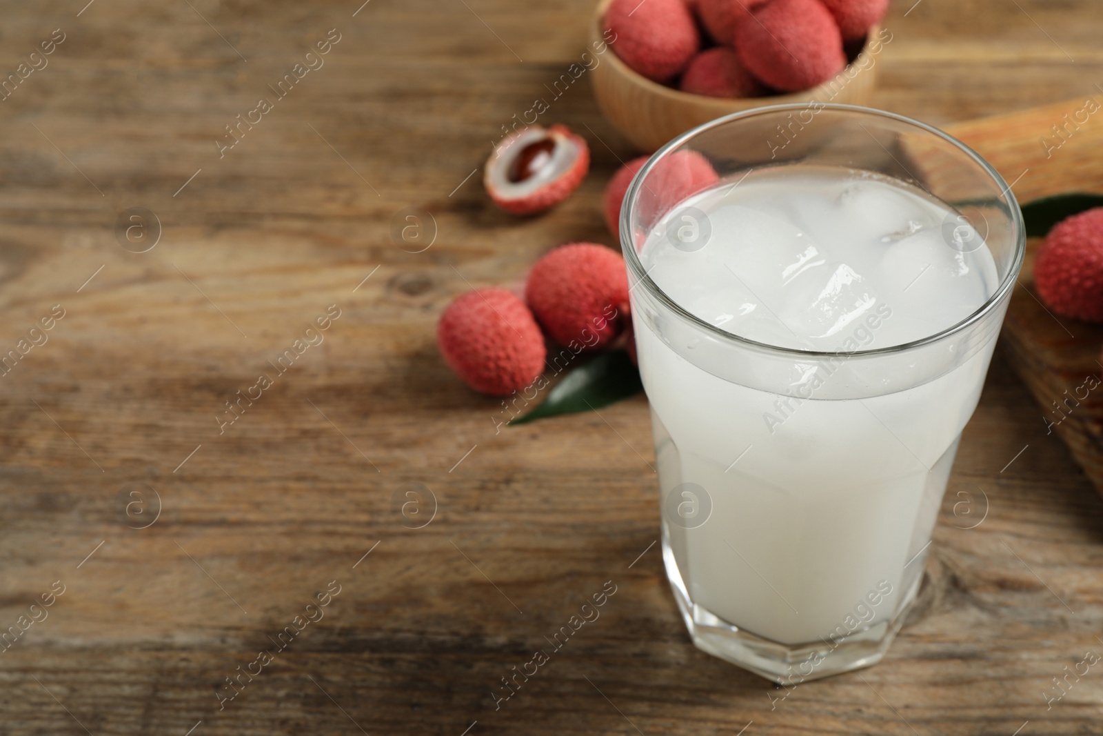 Photo of Fresh lychee juice on wooden table. Space for text