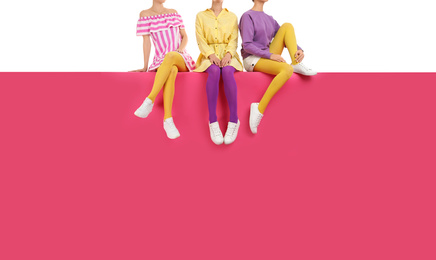 Group of women wearing bright tights and stylish shoes sitting on color background, closeup