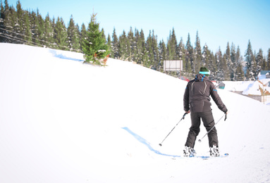 Photo of Man skiing at mountain resort, space for text. Winter vacation
