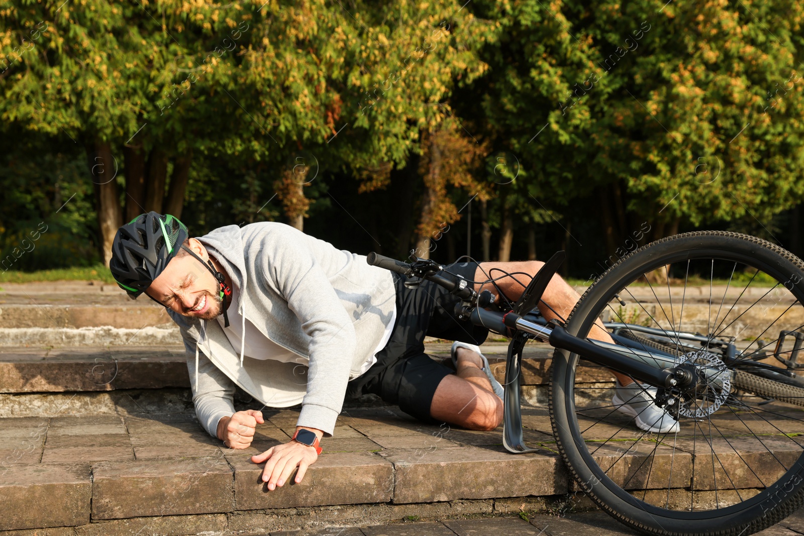 Photo of Man fallen off his bicycle on steps outdoors