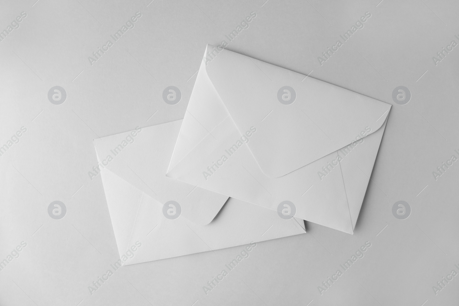 Photo of White paper envelopes on light grey background, top view