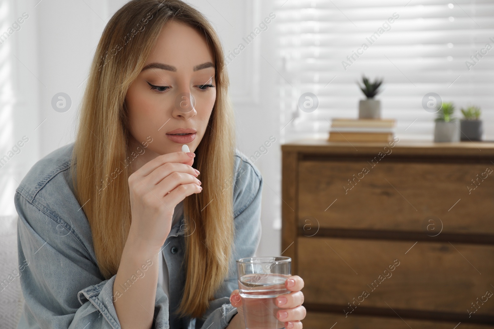 Photo of Young woman taking abortion pill at home