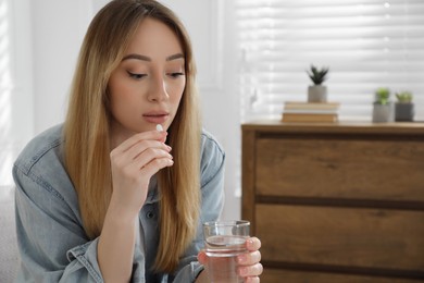 Young woman taking abortion pill at home