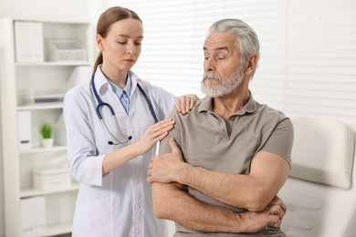 Arthritis symptoms. Doctor examining patient with shoulder pain in hospital